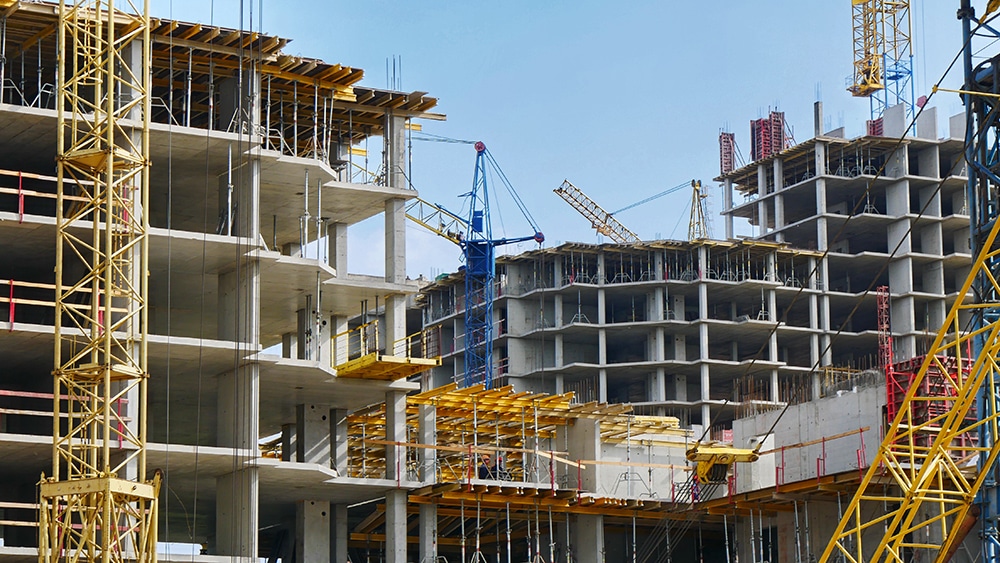 buildings being constructed with cranes