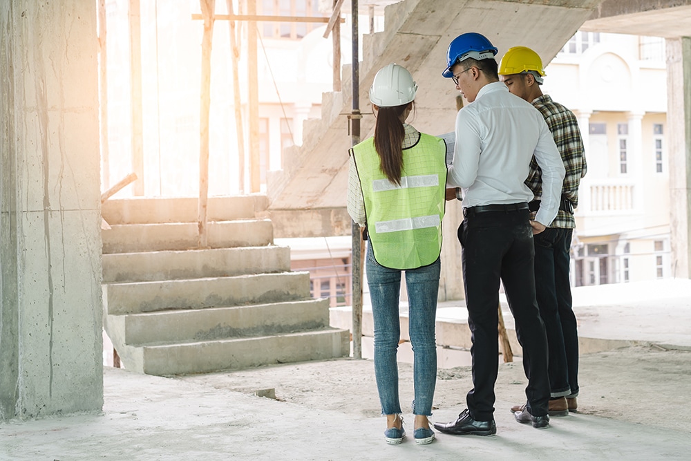 Asian contractor and engineer inspecting material in construction building.