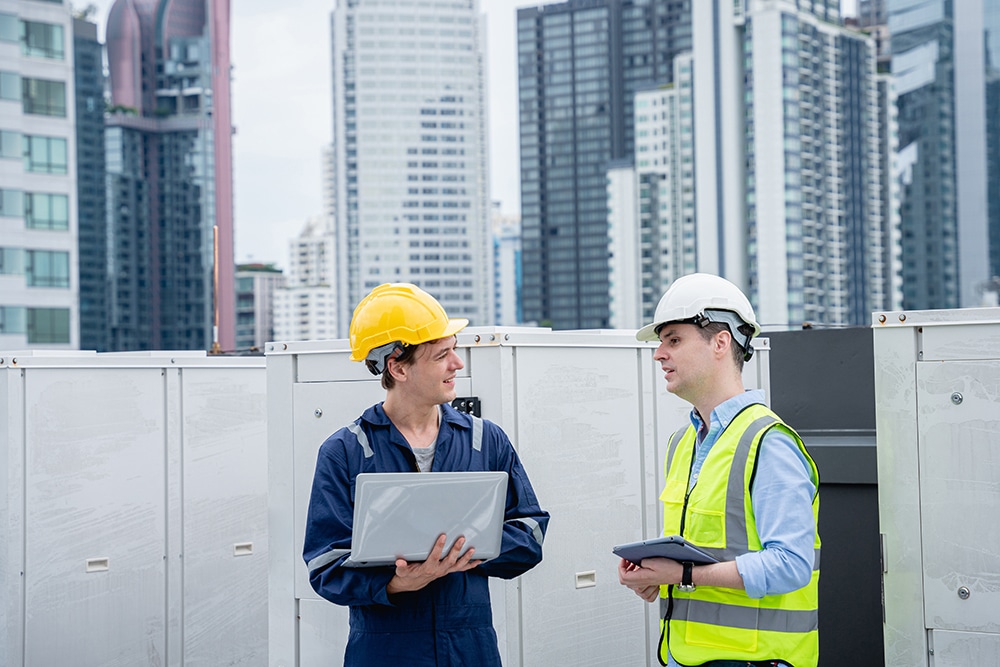 A group of engineers is inspecting the air conditioning cooling system of a large building or industrial facility.