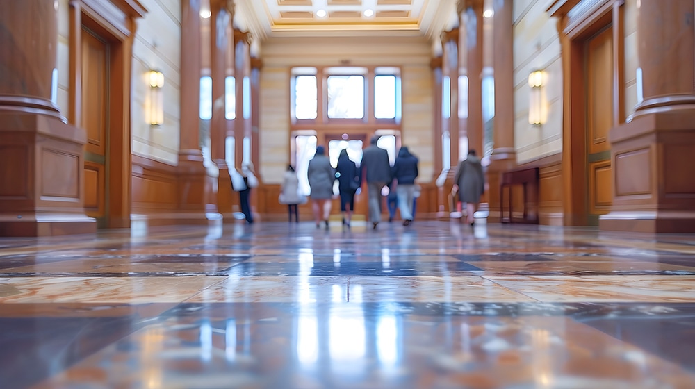 Blurred and defocused image of the entrance to a courtroom,with people walking through the impressive and ornate hallway.